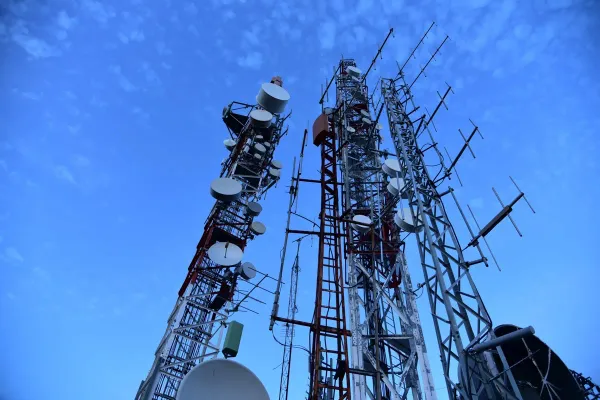 Three large radio towers festooned with antennas and satellite dishes.