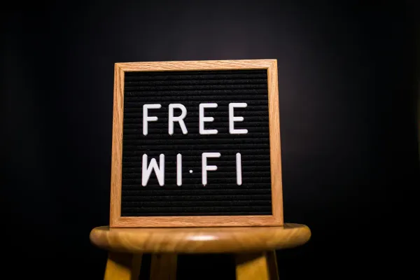 A sign perched on a wooden stool.  The sign reads "Free WiFi".